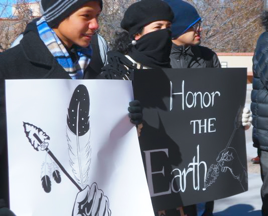 Young activist hold signs at the Santa Fe Idle No More flashmob.